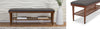 Wooden bench with gray cushion on a textured wall background